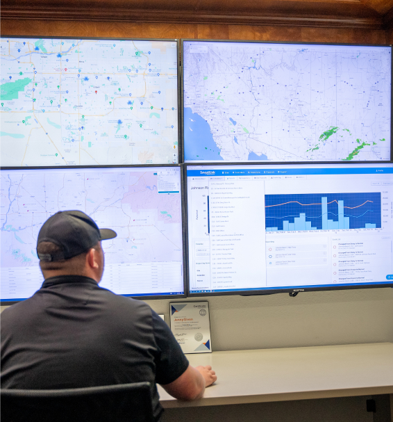 Man sitting in front of four giant screens with the SmartLink Network application on them